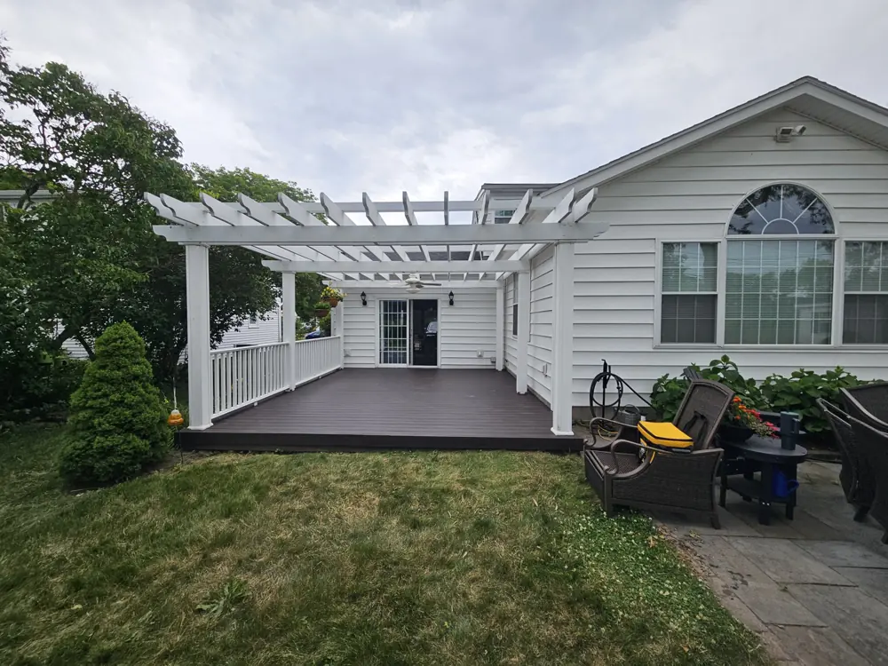 White pergola over a composite deck at the back of a house