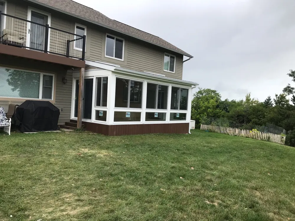 Sunroom addition with a run of windows along the back of a two-storey house