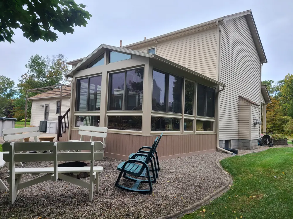 Sunroom with full-height windows and a stone patio alongside